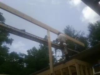 Carpenter setting a ridge beam over a new addition frame — Ice Dam Removal by Roofing Brothers in Pell Lake