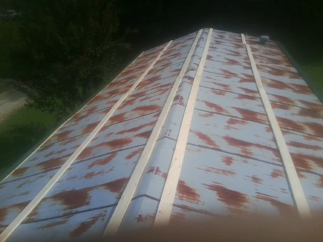 Rusted metal roof panels with new wood purlins before replacement — Storm Damage Roof Repair in Pell Lake by Roofing Brothers