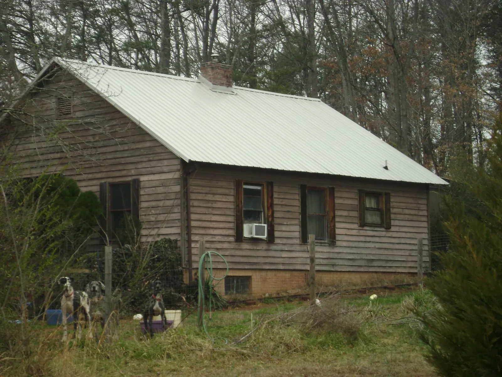 White metal roof on an old wood sided farmhouse, from a Metal Roof Installation job in Pell Lake