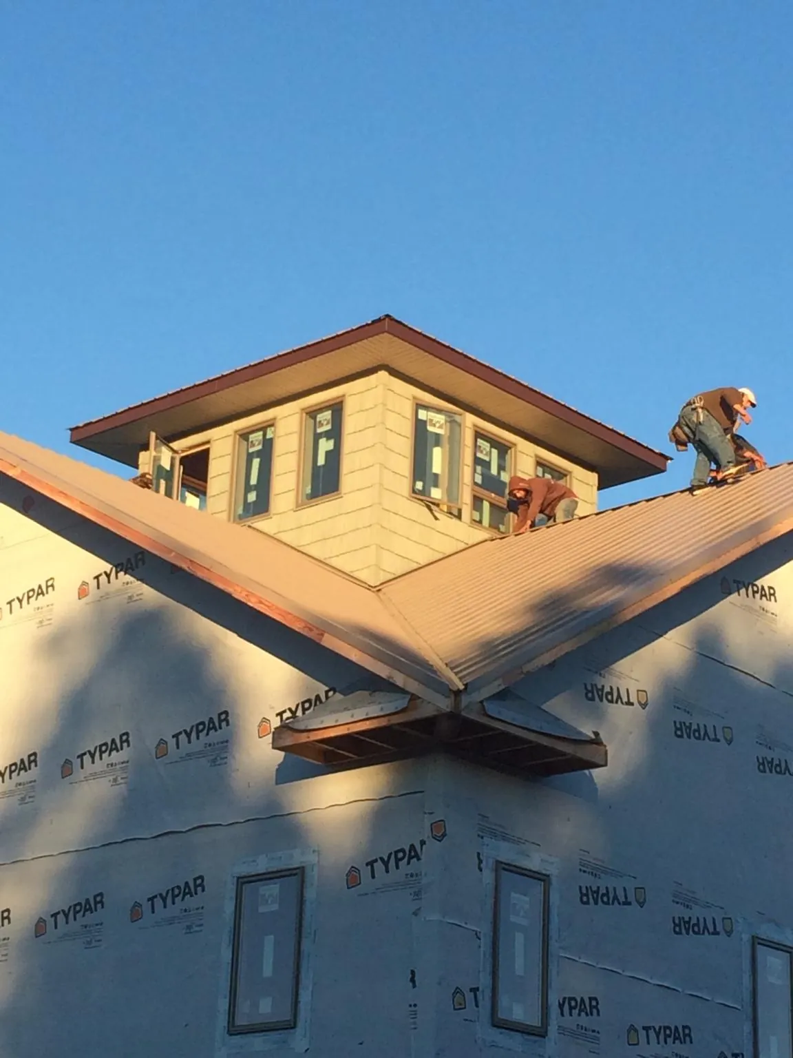 Roofers working around a rooftop cupola on a new metal roof at sunset — Roof Waterproofing in Pell Lake by Roofing Brothers